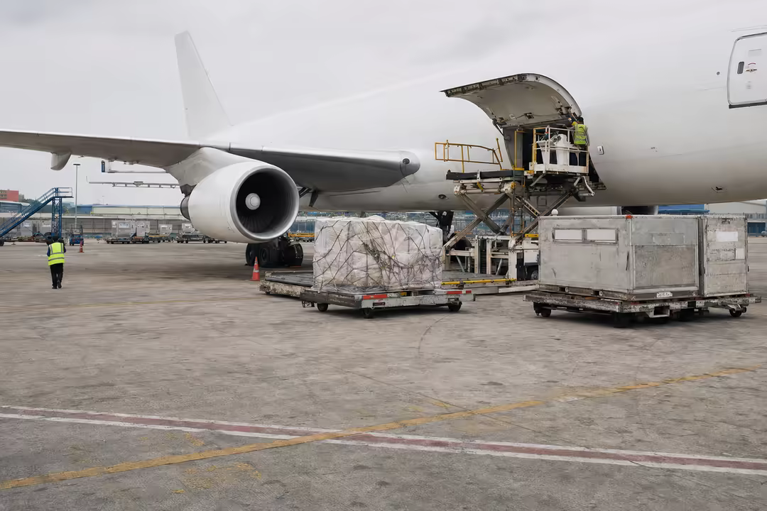 Palletised air cargo waiting beside a freighter on the tarmac