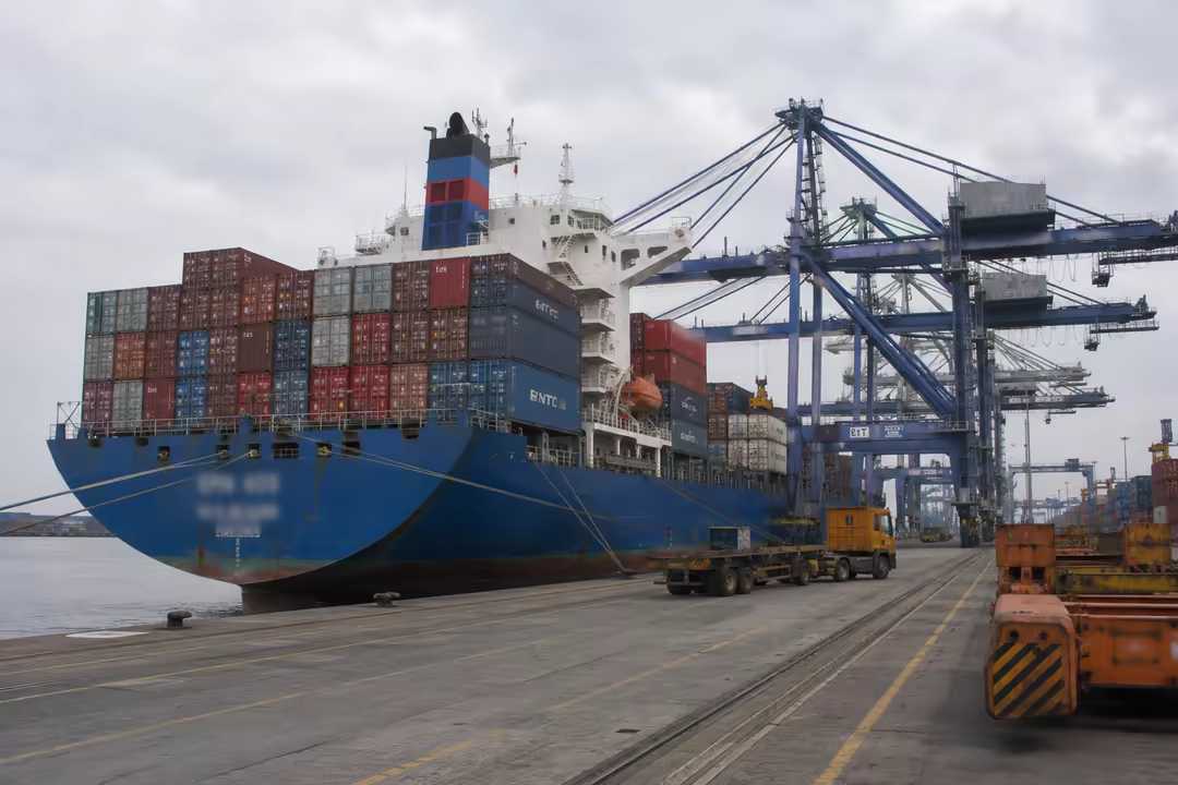 Laden container ship alongside the quay cranes at the terminal