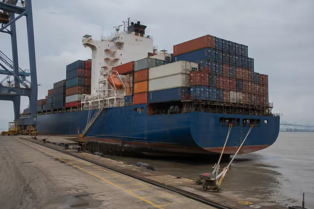 Moored container ship being worked at the harbour quay